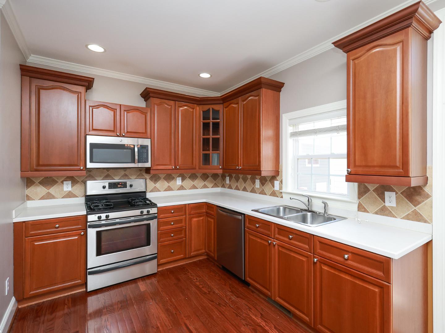 1155 Harp Street Raleigh, NC 27604 - Photo 10 of 33 a kitchen with stainless steel appliances a stove sink and cabinets