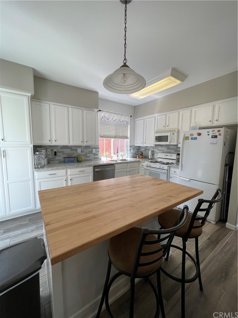 2832 Cottage Lane Paso Robles, CA 93446 - Photo 8 of 19 a kitchen with stainless steel appliances granite countertop a table chairs sink refrigerator and cabinets