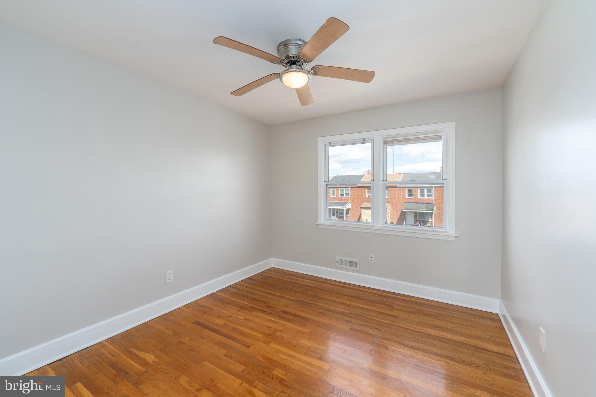 1738 Stokesley Road Baltimore, MD 21222 - Photo 11 of 34 an empty room with wooden floor and windows