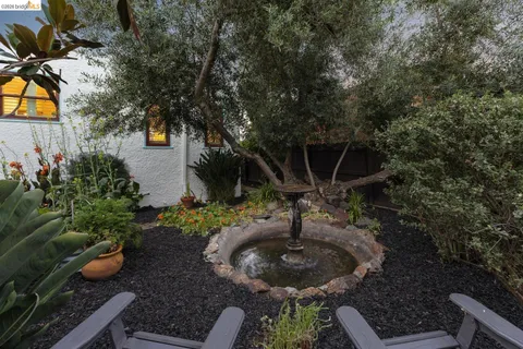 a backyard of a house with fountain table and chairs