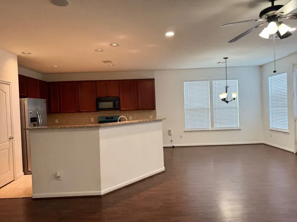 a view of kitchen with stainless steel appliances granite countertop a stove a sink and a refrigerator