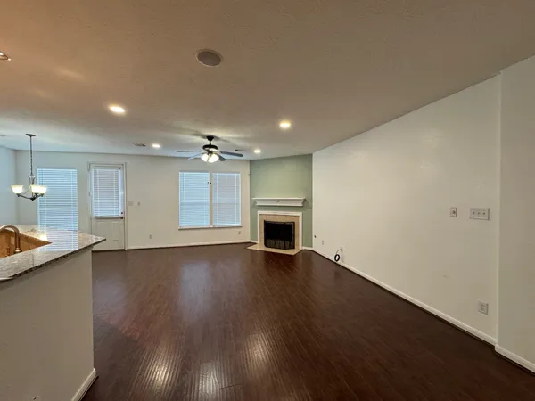 an empty room with wooden floor fireplace and cabinet