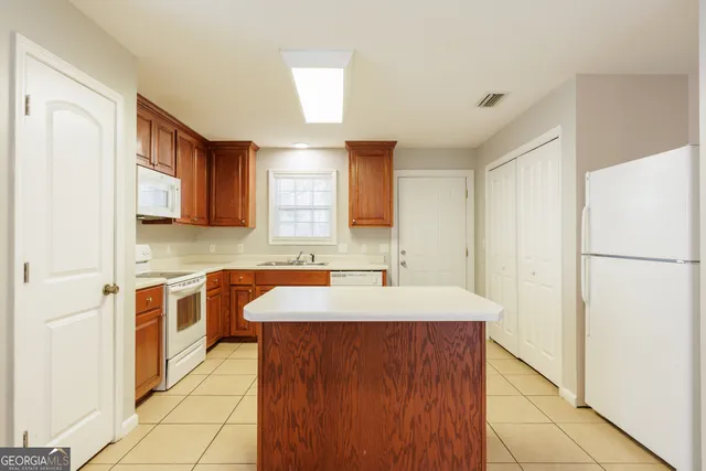 a kitchen with a sink a stove a refrigerator and cabinets