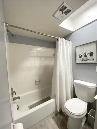 a white toilet sitting next to a bath tub and shower