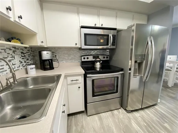 a kitchen with a refrigerator microwave and sink