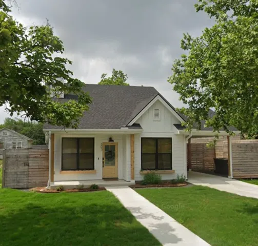 a front view of a house with a garden and yard