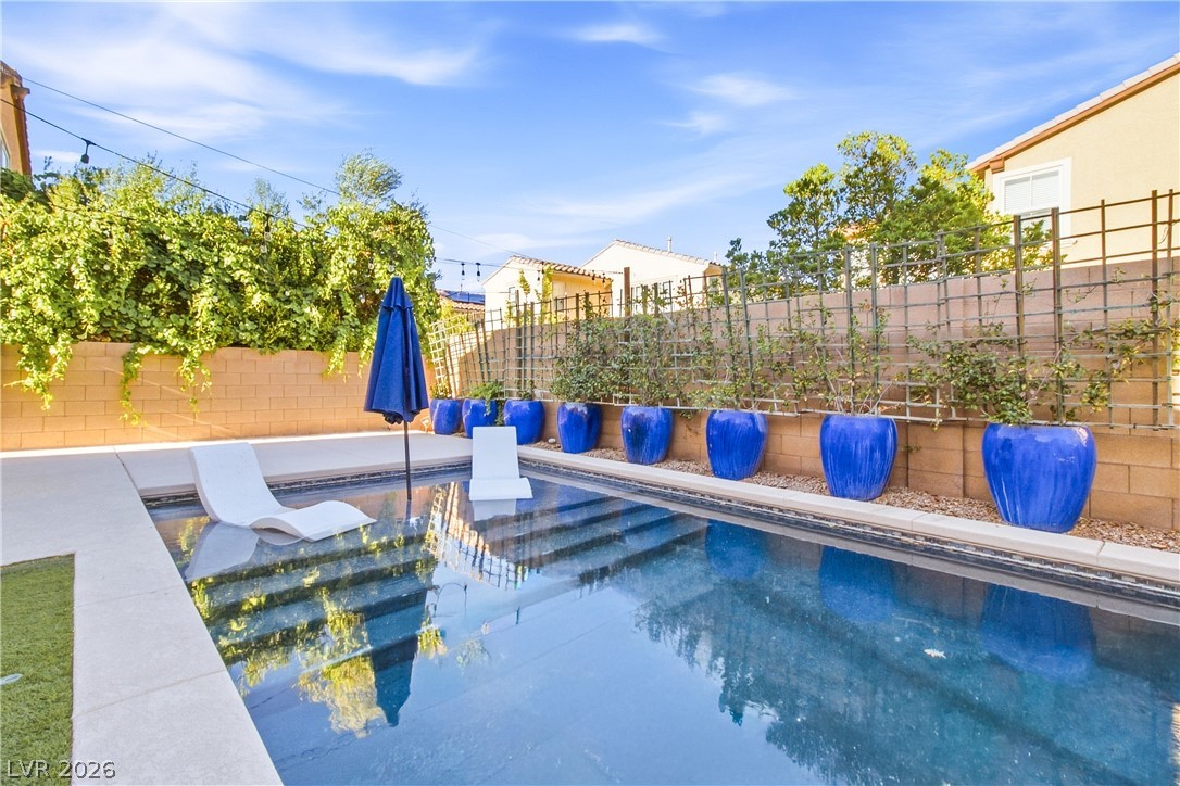 2182 Trivero Street Henderson, NV 89044 - Photo 45 of 50 A sparkling in-ground pool is framed by clean concrete decking and a block wall fence.