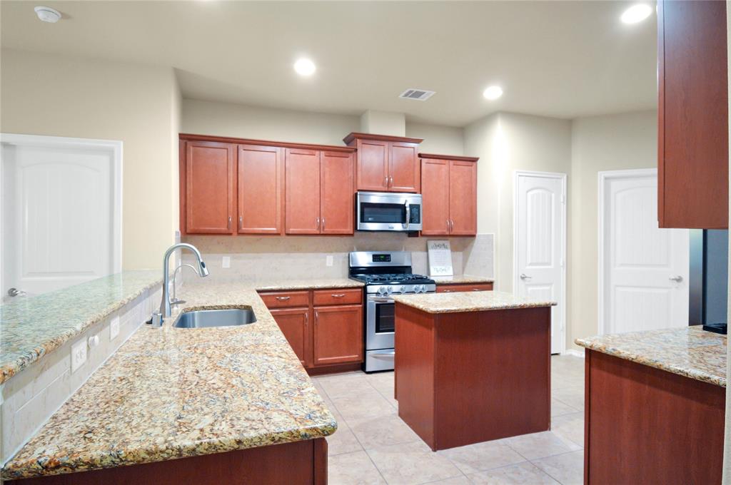 3312 Founders Way Melissa, TX 75454 - Photo 8 of 11 a kitchen with granite countertop wooden cabinets and a sink