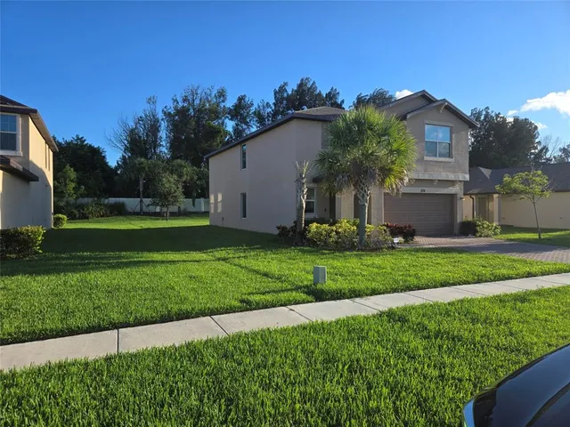 a front view of a house with a yard and trees