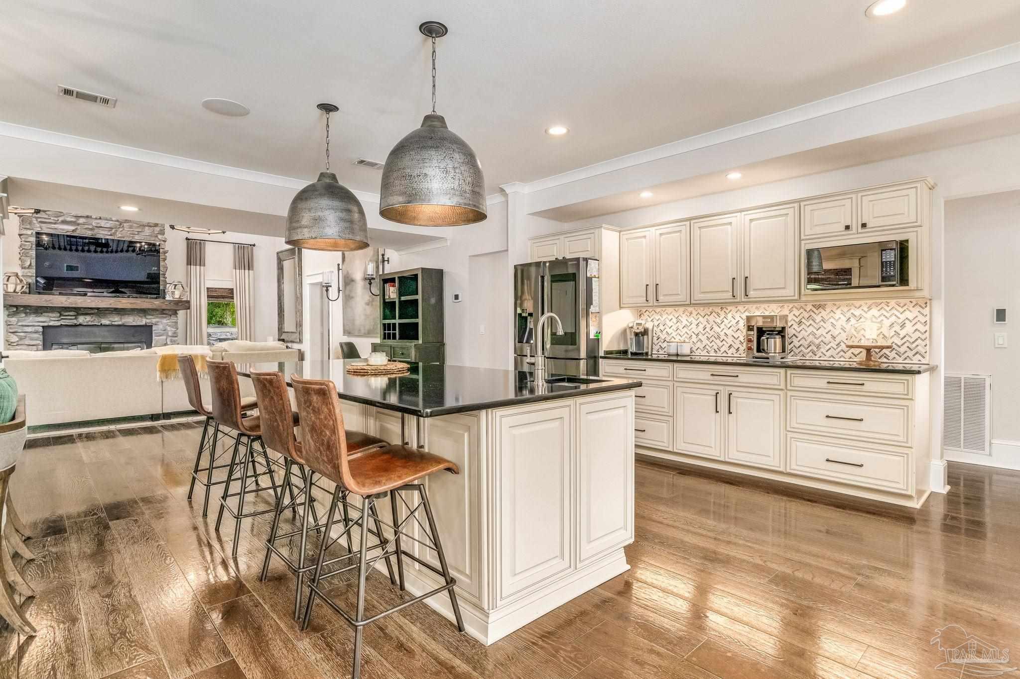 9050 Salter Road Pace, FL 32571 - Photo 11 of 66 a kitchen with stainless steel appliances kitchen island granite countertop a stove a sink and a refrigerator
