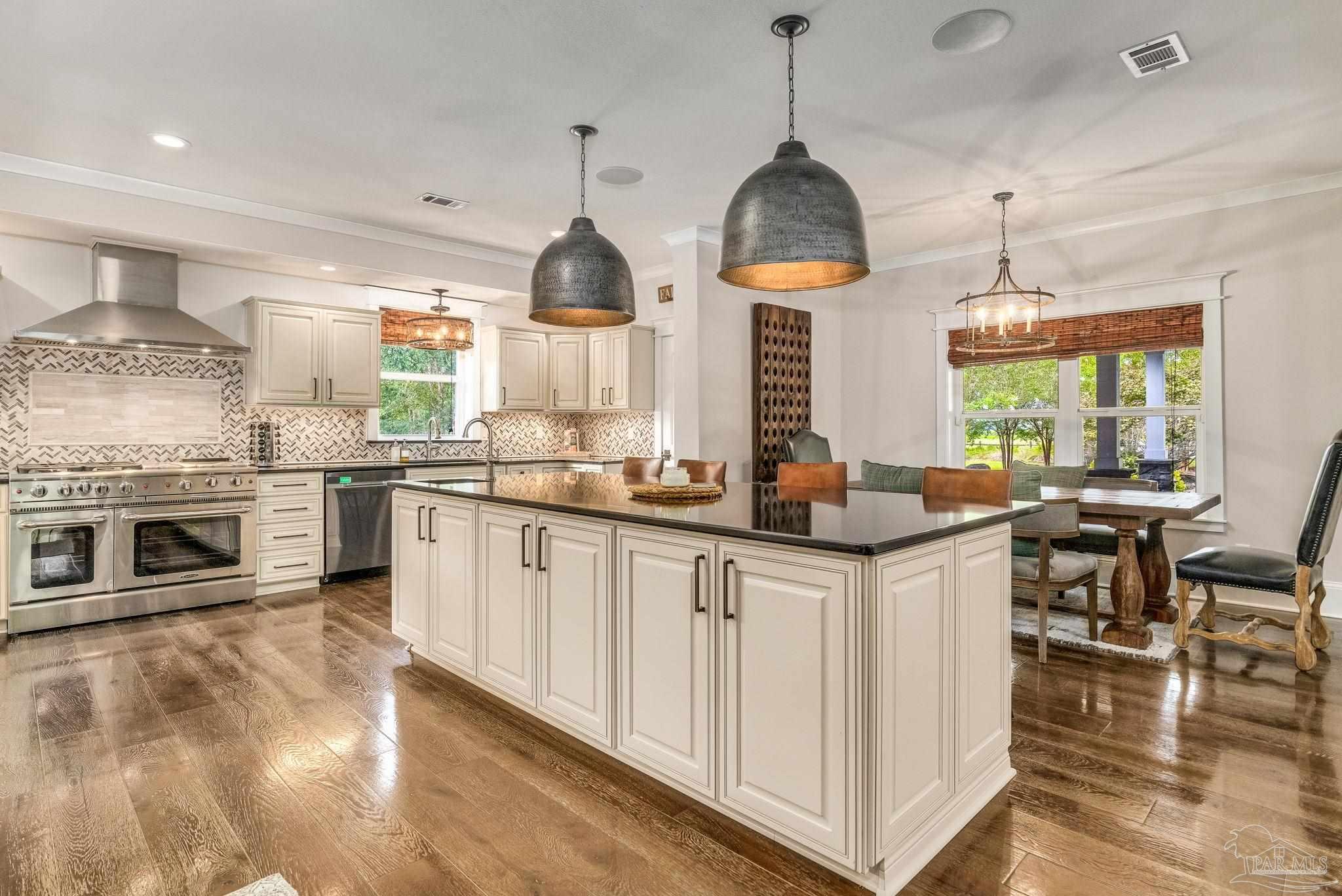 9050 Salter Road Pace, FL 32571 - Photo 12 of 66 a kitchen with granite countertop a stove a sink a center island and living room view