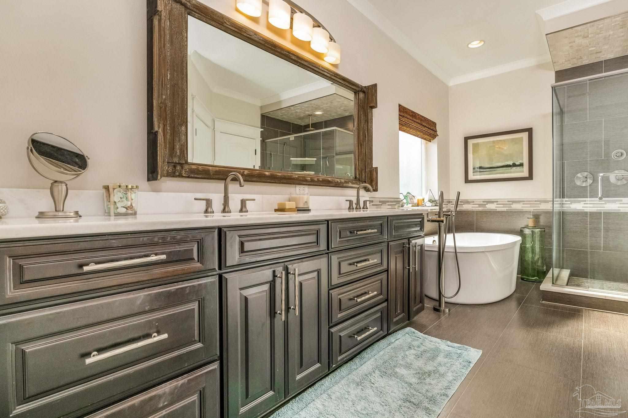 9050 Salter Road Pace, FL 32571 - Photo 16 of 66 a bathroom with a double vanity sink a mirror and a bathtub