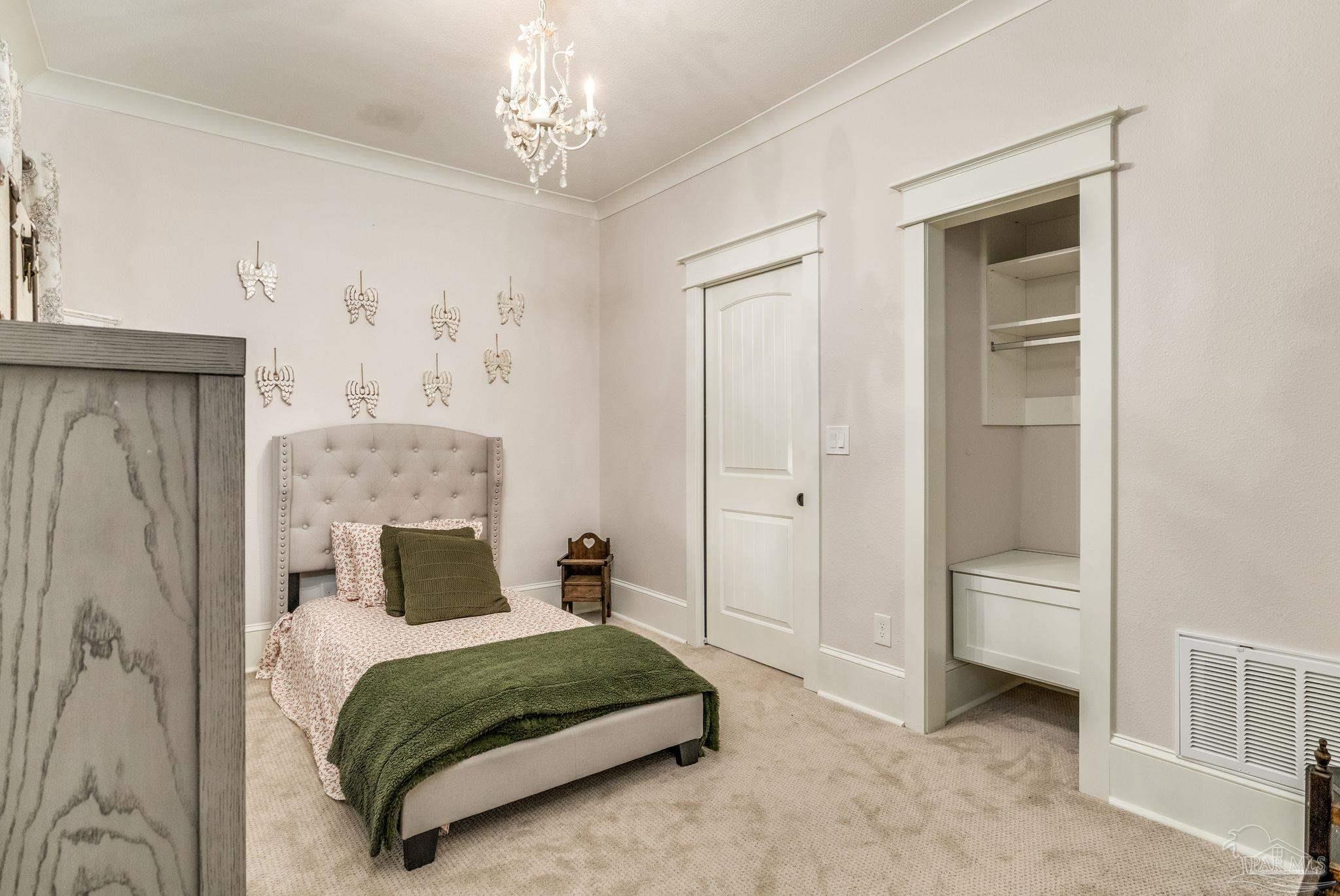 9050 Salter Road Pace, FL 32571 - Photo 20 of 66 a bedroom with a bed and a chandelier