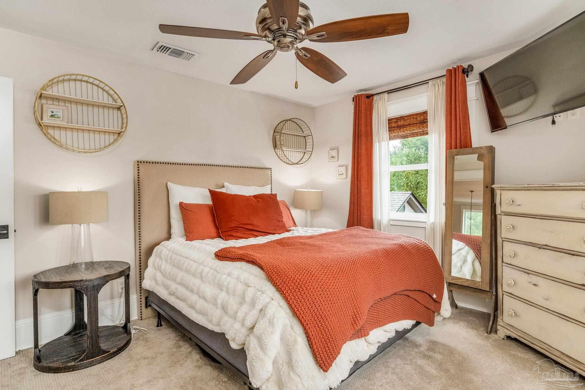 9050 Salter Road Pace, FL 32571 - Photo 25 of 66 a bedroom with a bed a mirror on dresser and a chandelier
