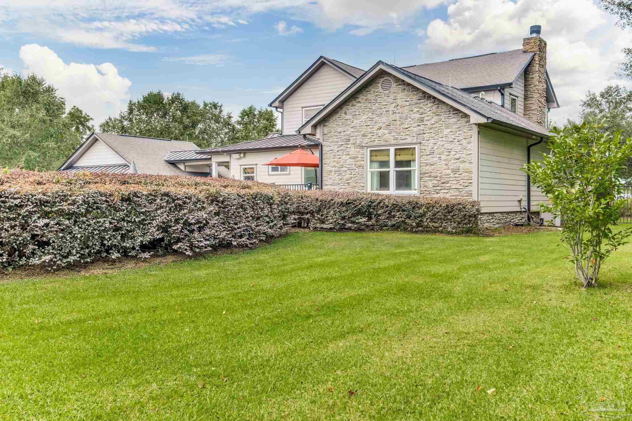 9050 Salter Road Pace, FL 32571 - Photo 30 of 66 a front view of a house with a garden