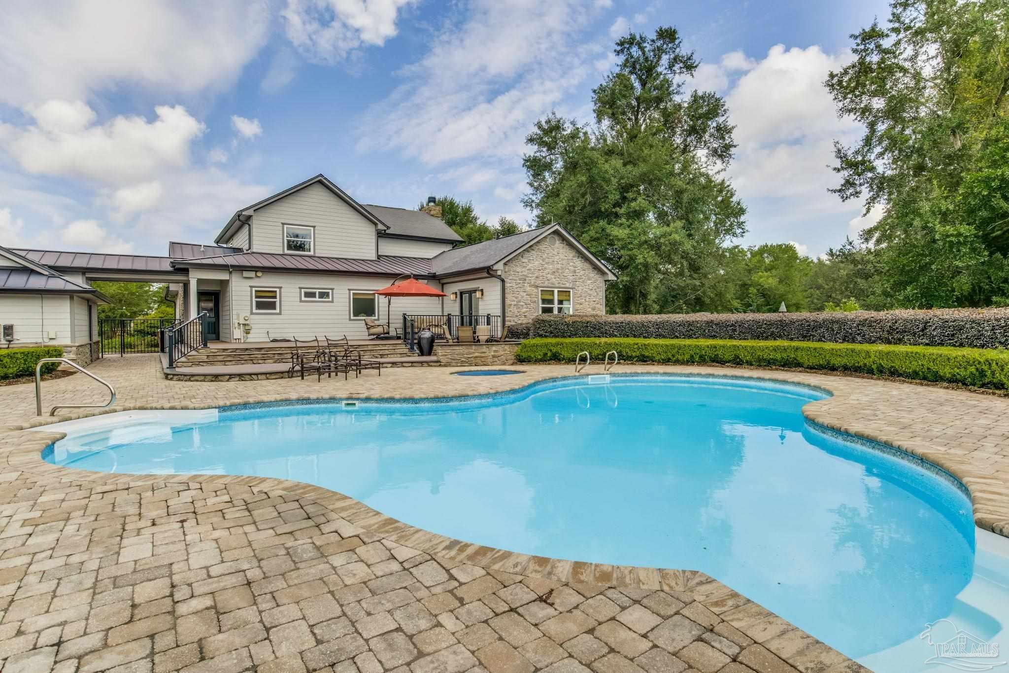 9050 Salter Road Pace, FL 32571 - Photo 37 of 66 a view of swimming pool with outdoor seating and house in the background