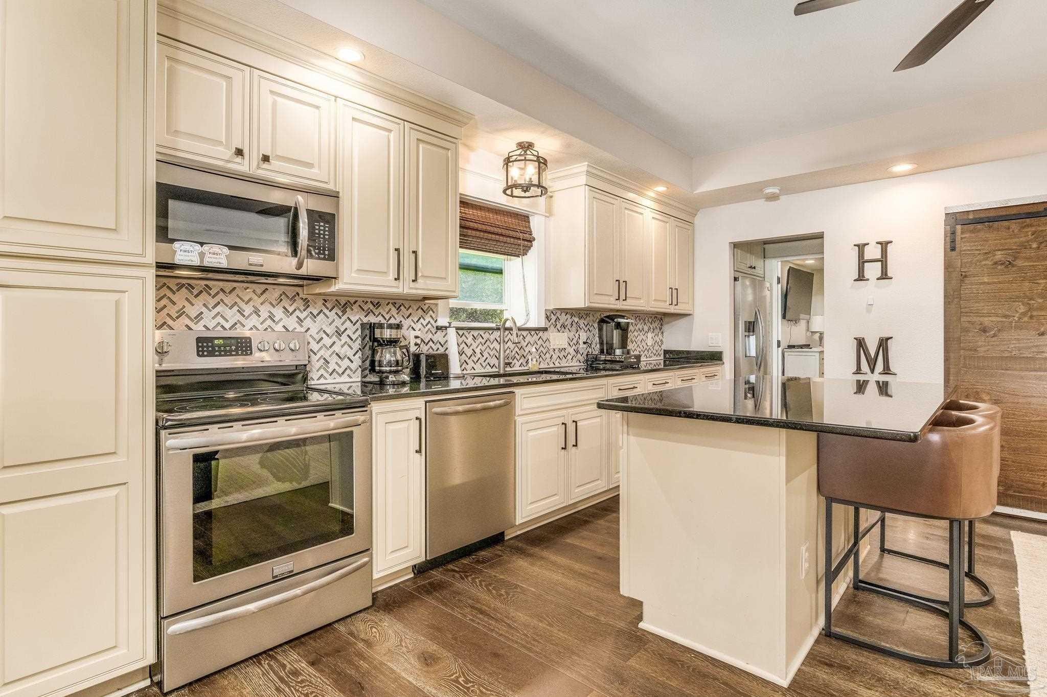 9050 Salter Road Pace, FL 32571 - Photo 43 of 66 a kitchen with stainless steel appliances white cabinets and a stove top oven
