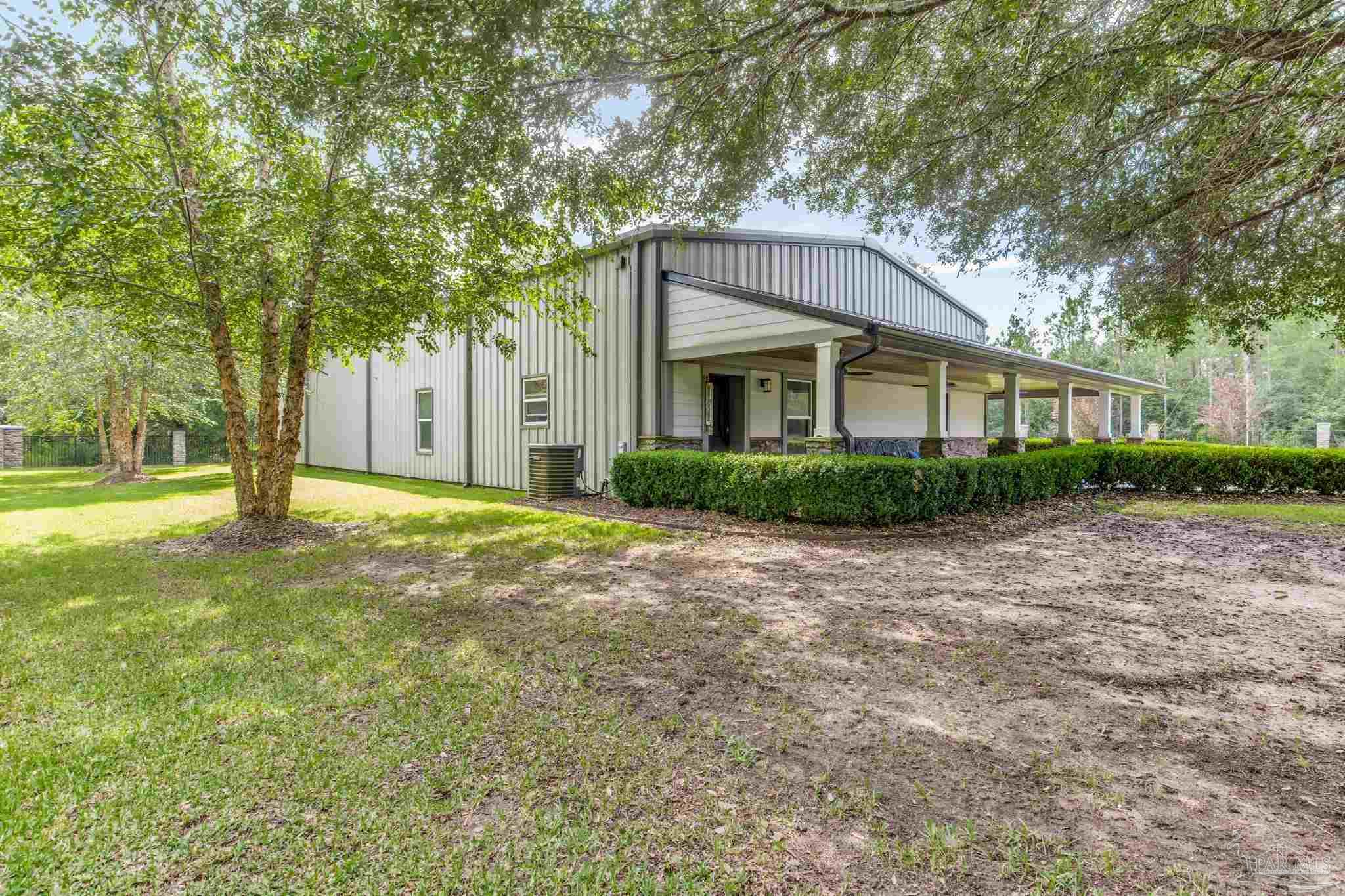 9050 Salter Road Pace, FL 32571 - Photo 61 of 66 a front view of a house with a yard and trees