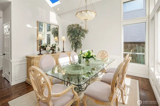 a dining room with furniture a chandelier and wooden floor