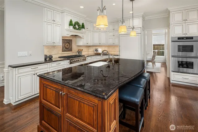 a kitchen with stainless steel appliances granite countertop a sink a stove and a refrigerator