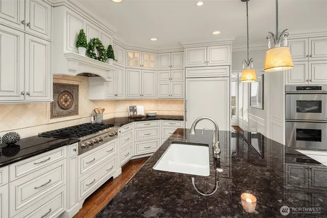 a kitchen with granite countertop a stove a sink a refrigerator and window