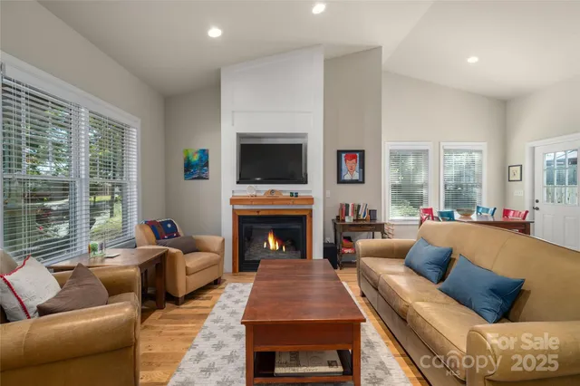 a living room with furniture a fireplace and a flat screen tv