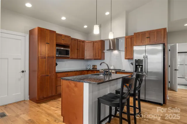 a kitchen with stainless steel appliances granite countertop a refrigerator a sink and a stove