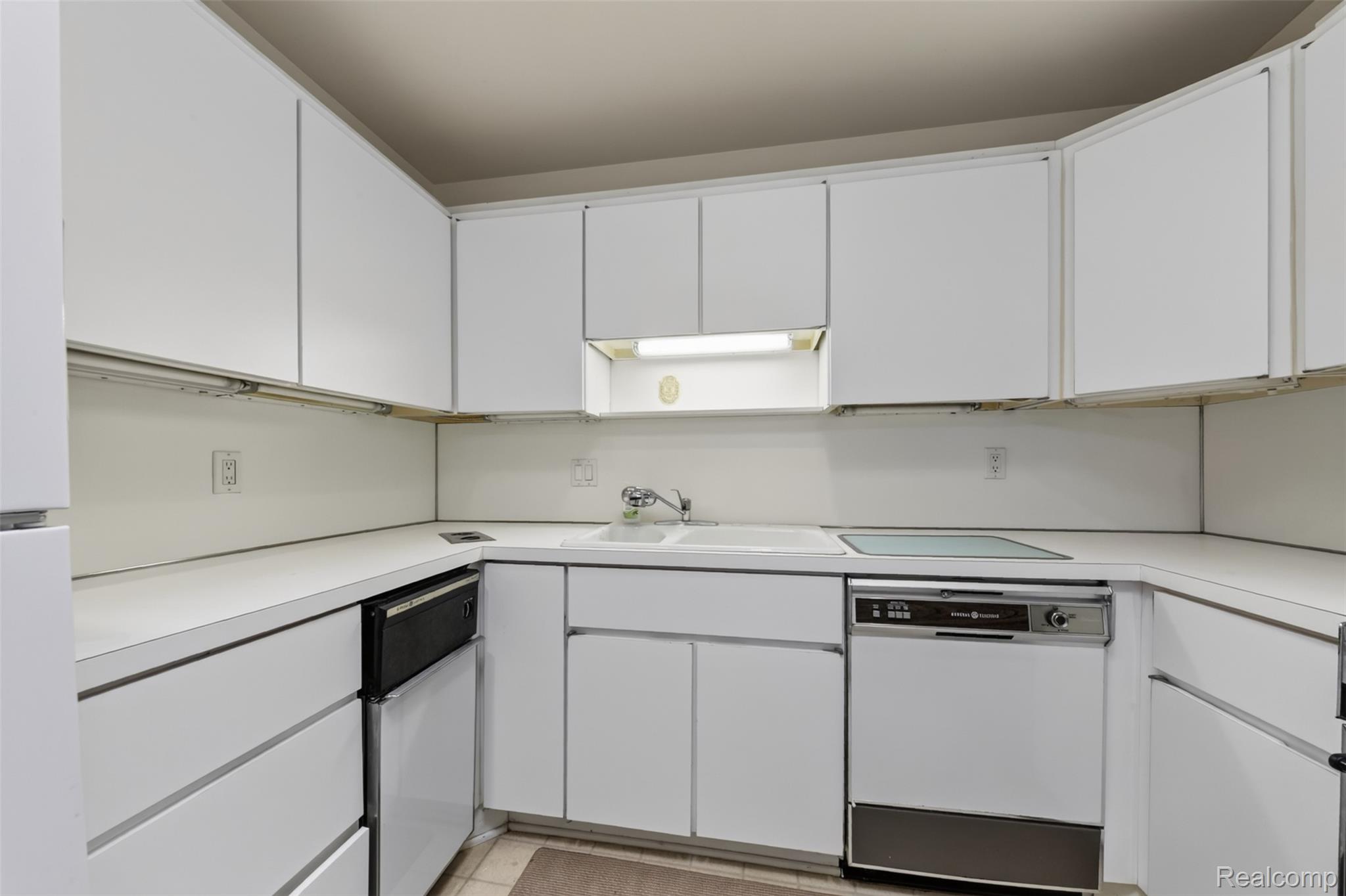 31915 West 14 Mile Road Farmington, MI 48334 - Photo 17 of 47 Efficient galley kitchen featuring white cabinetry with integrated hardware, stainless steel dishwasher, laminate countertops, and a window above the sink providing natural light