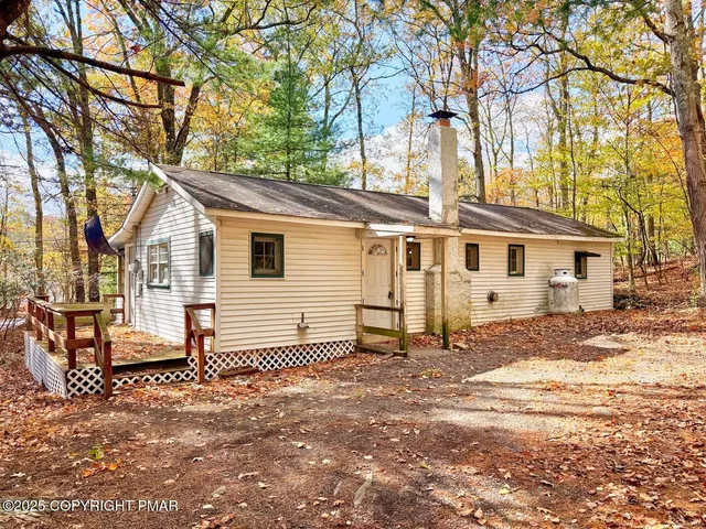 a view of a house with a yard covered in snow