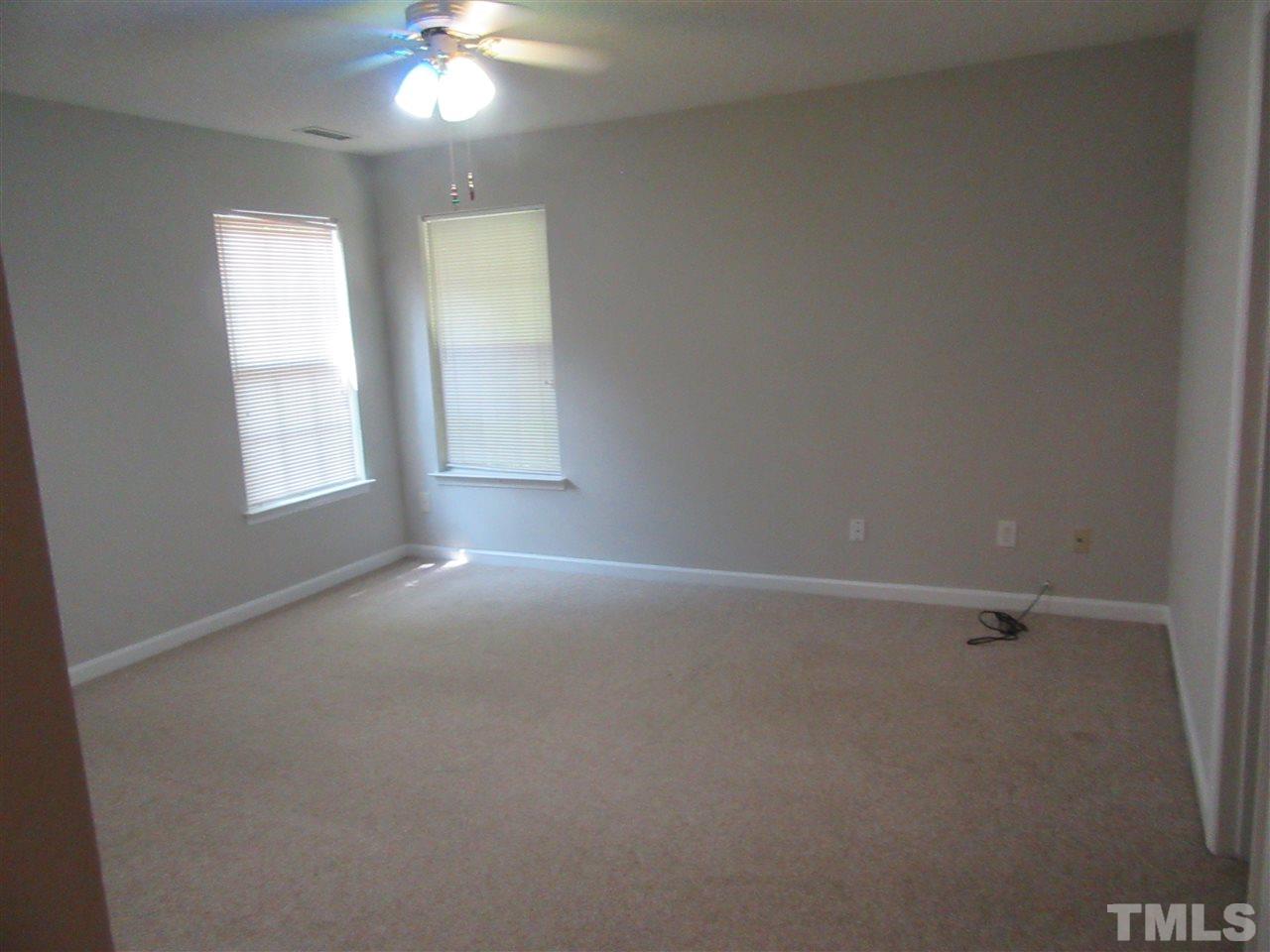 5113 Silverdene Street Raleigh, NC 27616 - Photo 12 of 25 an empty room with windows and fan