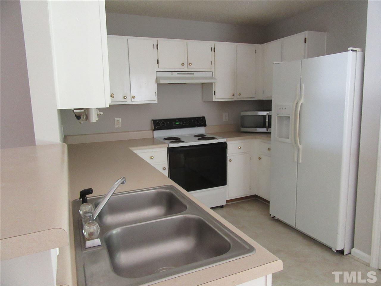 5113 Silverdene Street Raleigh, NC 27616 - Photo 18 of 25 a kitchen with a refrigerator sink and white cabinets