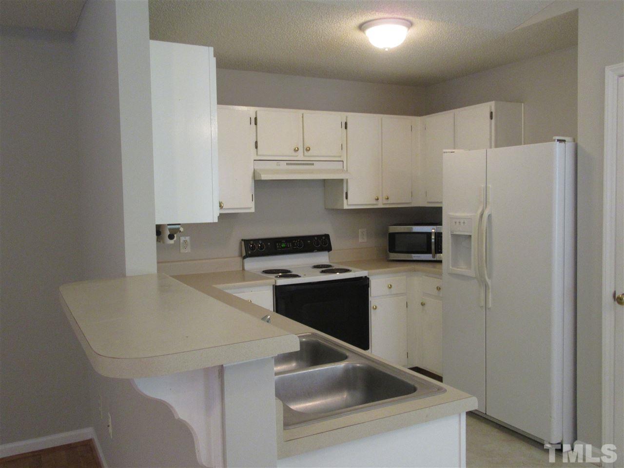 5113 Silverdene Street Raleigh, NC 27616 - Photo 4 of 25 a kitchen with a sink a stove and refrigerator
