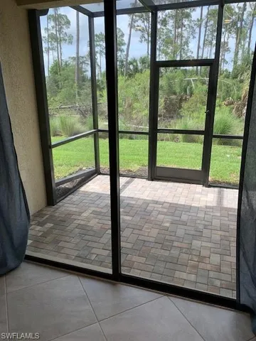 a view of a room with an empty floor and large window