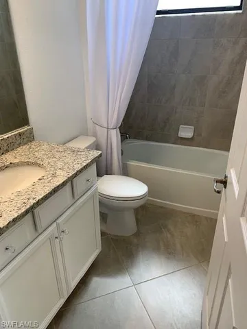 a bathroom with a granite countertop sink toilet and a mirror