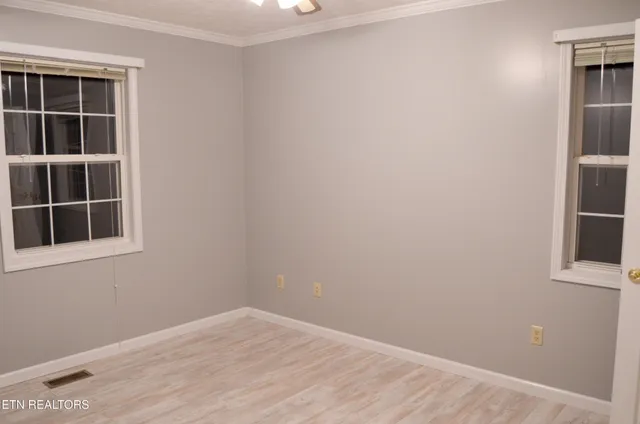 an empty room with windows and closet