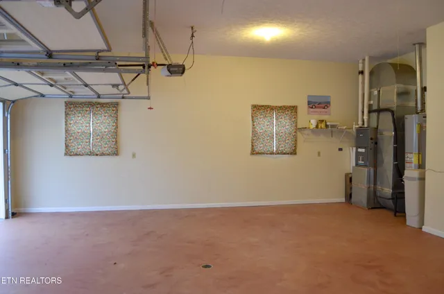 a house that is sitting in the grass with large trees