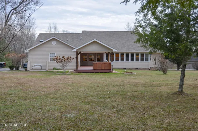 a front view of house with yard and trees in the background