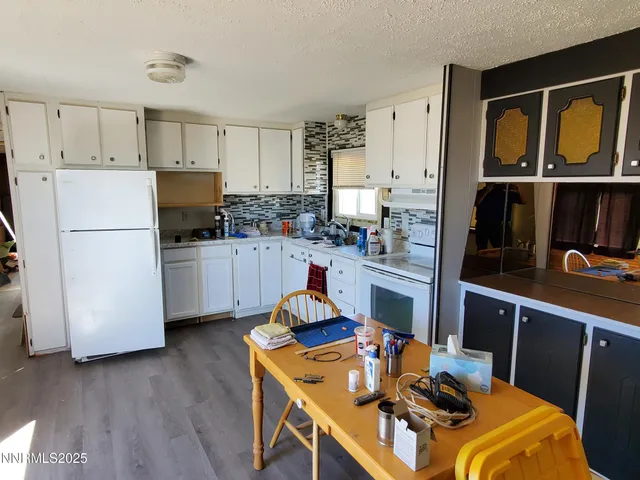 a kitchen with a refrigerator a stove top oven a sink dishwasher and white cabinets with wooden floor