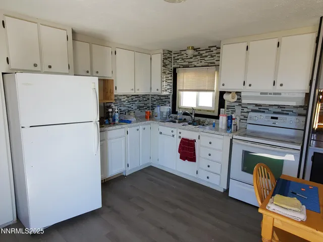 a kitchen with a refrigerator stove and white cabinets