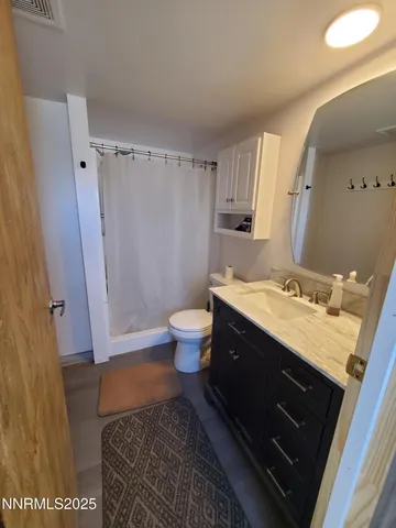 a spacious bathroom with a granite countertop sink toilet and shower