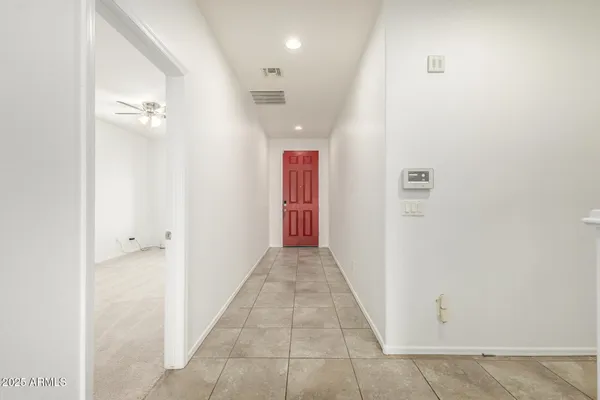 a view of a hallway with wooden floor and a bathroom
