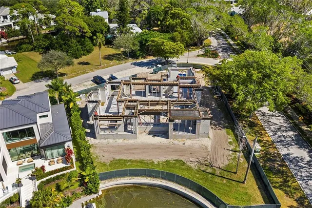 an aerial view of residential houses with outdoor space and trees