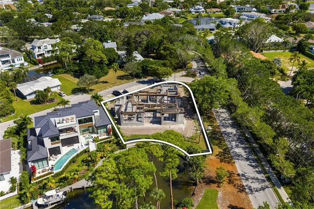 an aerial view of a swimming pool with a yard and outdoor seating