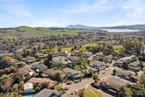 an aerial view of residential houses with outdoor space and trees