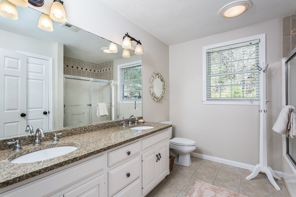 4 Griffin Road Franklin, MA 02038 - Photo 28 of 42 a bathroom with a granite countertop double vanity sink a mirror and a toilet
