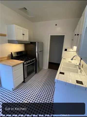 a view of a hallway with wooden floor and cabinet