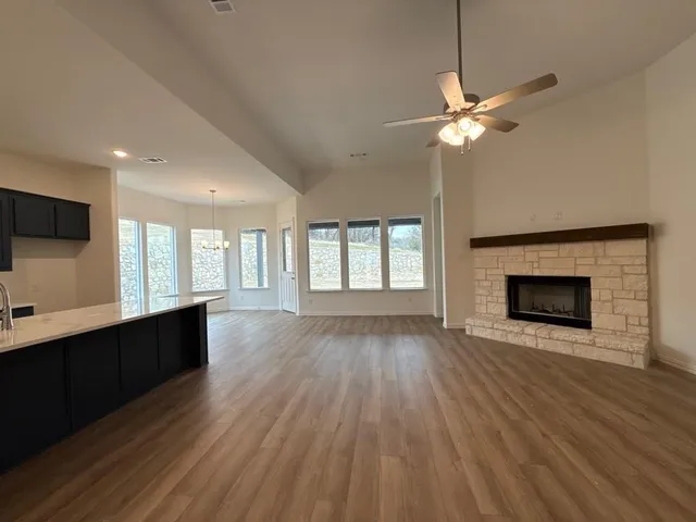 a view of an empty room with a fireplace and a window