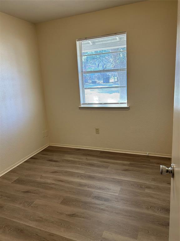 1836 Coral Road Pelican Bay, TX 76020 - Photo 9 of 13 a view of an empty room with wooden floor and a window