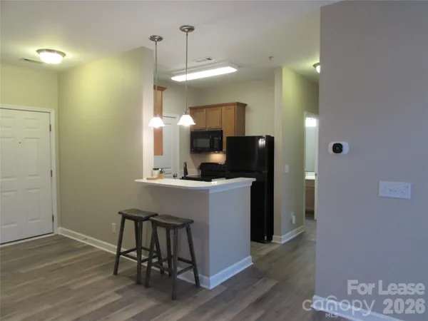 a kitchen with a table chairs refrigerator and microwave