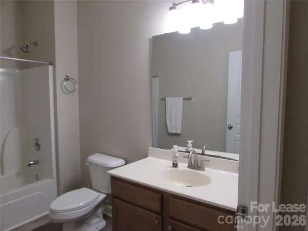 a bathroom with a sink toilet vanity and shower
